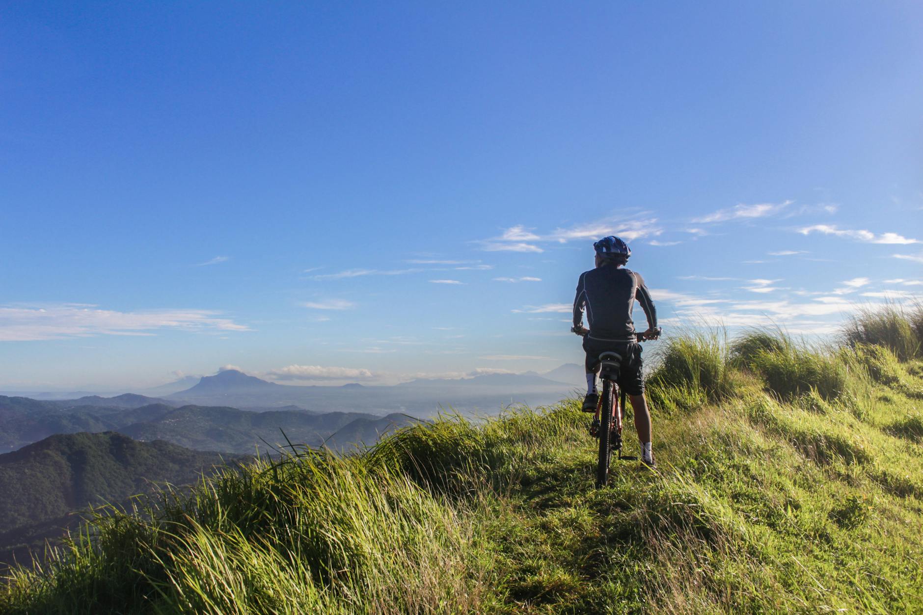 man riding bicycle on green grass field